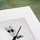 silhouette of a dragonfly insect on a small branch with mottled background, black and white art print